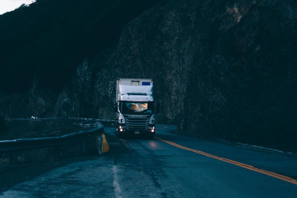 Un camion porteur sur une route de montagne au crépuscule